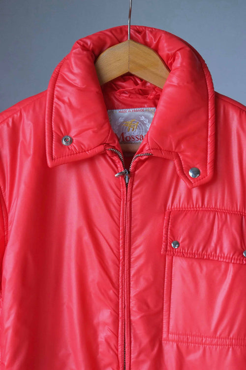 Close-up of the jacket's upper section, highlighting the glossy finish, the "Made in France" Mossant woven label, and the silver-tone snap hardware on the collar and pocket.