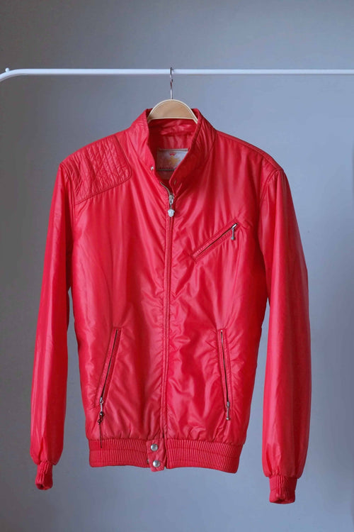 Front full-length view of a bright red vintage 70s Mossant lightweight puffer ski jacket hanging on a white rack, featuring a ribbed waistband and cuffs.