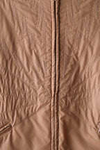 Detailed view of the unique decorative "lightning bolt" zigzag stitching on the front of the camel brown Mossant jacket.