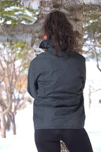 Back view of the vintage 70s Mossant black ski jacket worn by a female model in a snowy outdoor setting, highlighting the textured quilting.