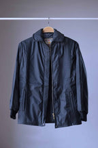 Studio shot of a black vintage Mossant 1970s ski jacket with an open zipper, showing the interior lining and ribbed knit cuffs.