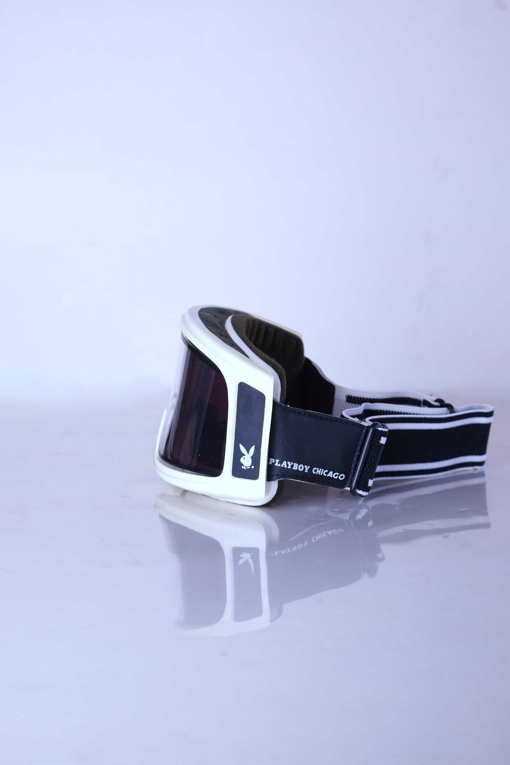 Side view of white Playboy Chicago ski goggles highlighting the rabbit head logo and intact interior foam.