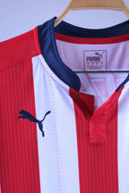Close-up of the jersey's collar area, showing the navy blue buttonless placket, the navy blue embroidered Puma cat logo on the front, and the printed Puma branding/sizing information inside the neckline.