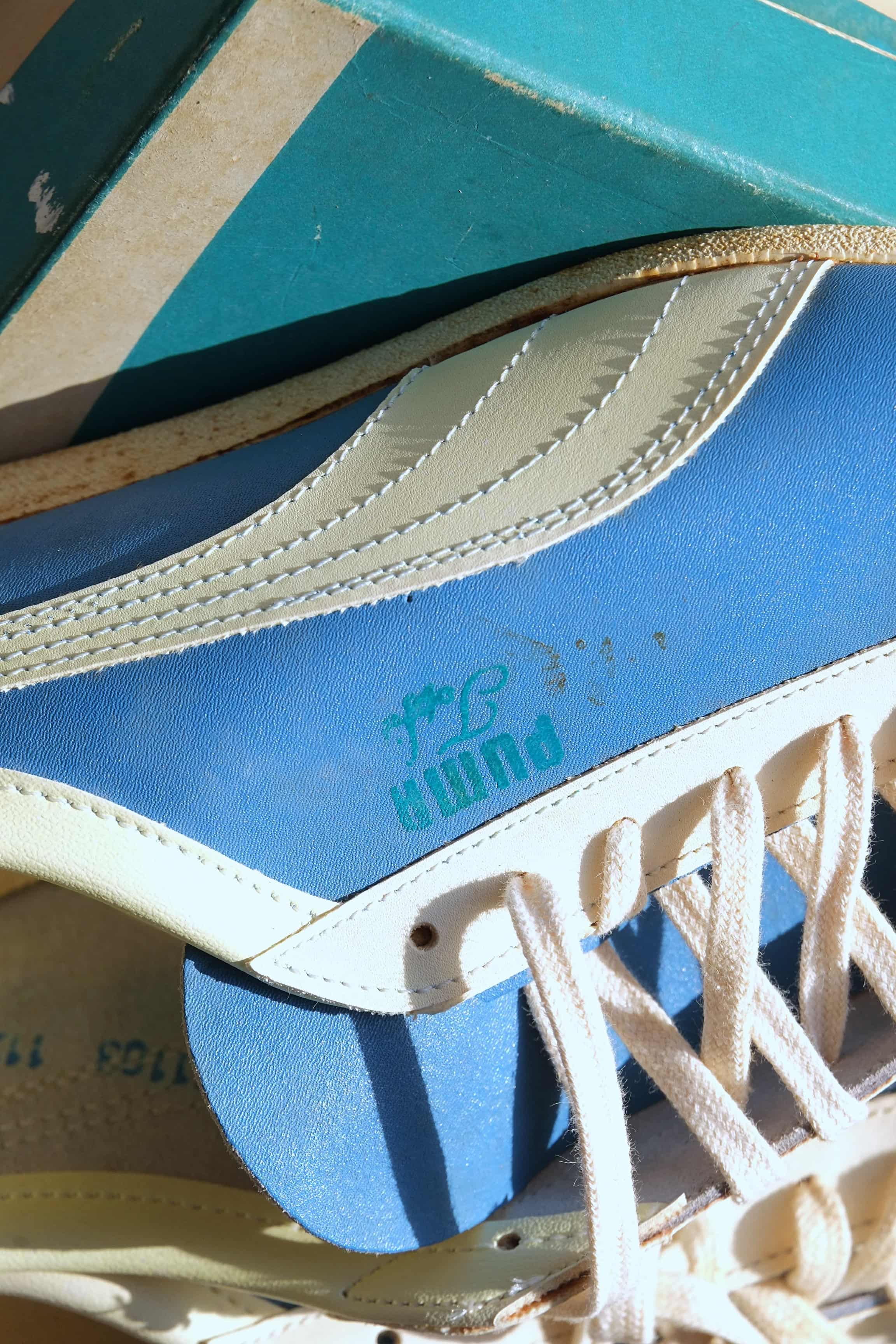 Detailed side view showing cream leather formstrip and teal Puma Top Fit branding on blue 1970s sneaker upper.