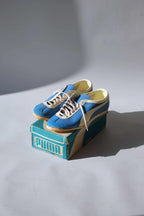 Three-quarter front view of vintage 1970s Puma Top Fit deadstock blue leather trainers displayed on original box.