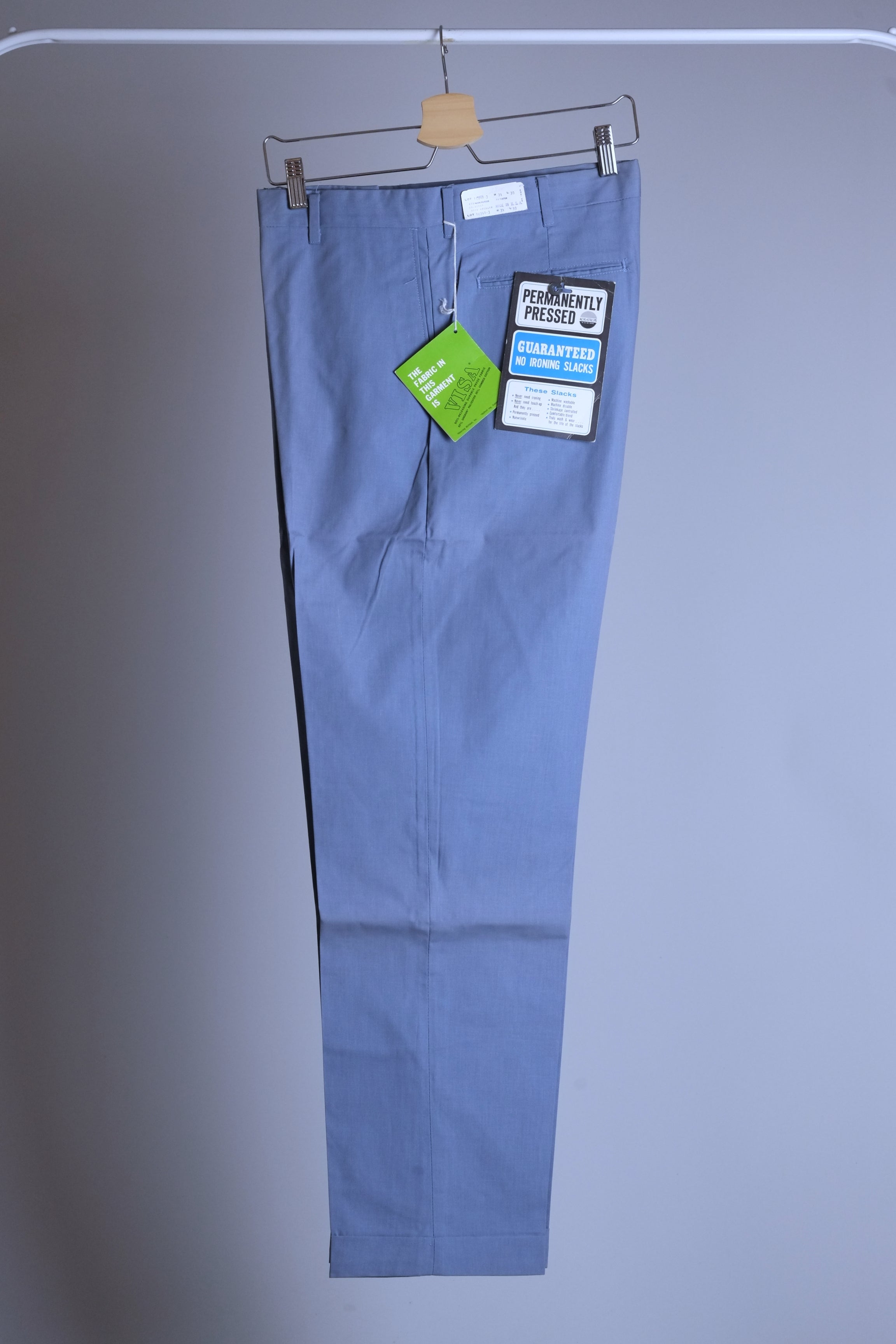 Side profile of a dusty blue pair of vintage Permanent Press tapered slacks showing the slim 70s silhouette and wrinkle-resistant fabric.