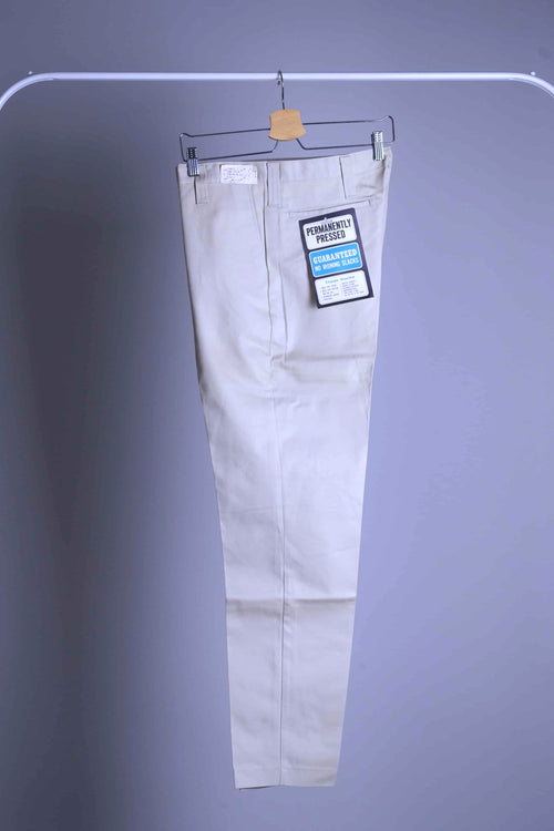 Side profile of a stone khaki pair of vintage Permanent Press tapered slacks showing the slim 70s silhouette and wrinkle-resistant fabric.