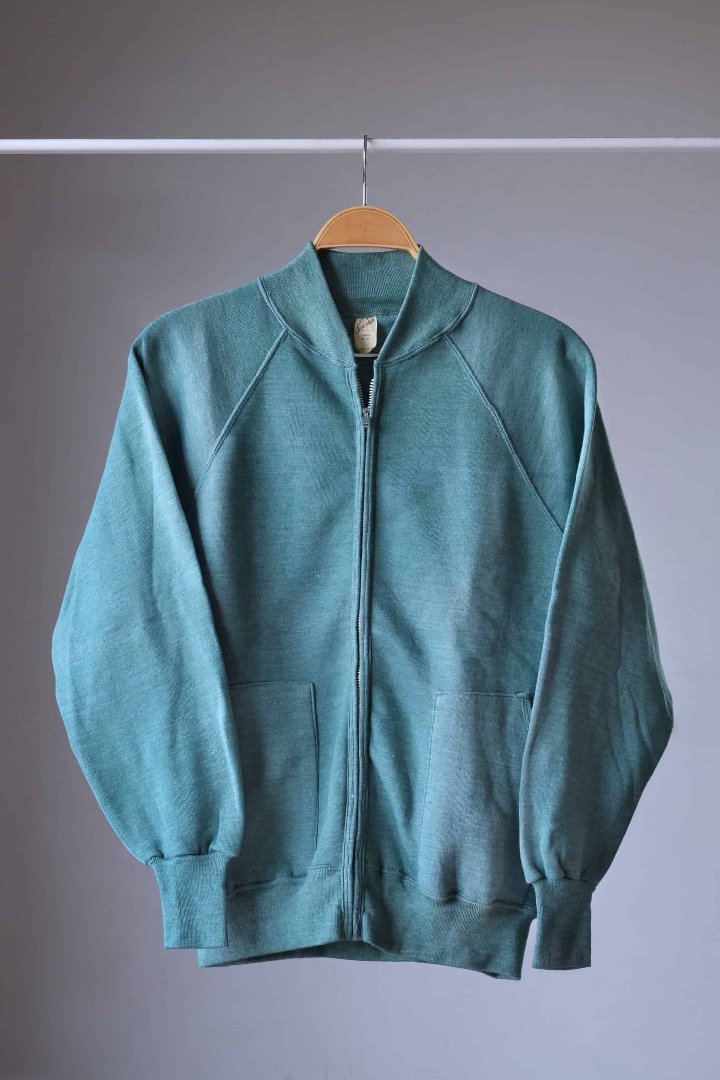 Heether green zipper sweatshirt on hanger