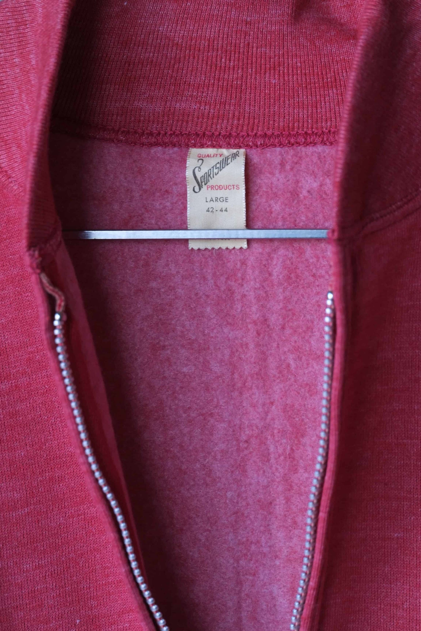 Close up of Heether red zipper sweatshirt on hanger