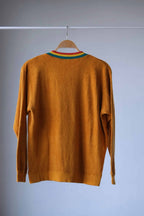 Back view of a Vintage 70s Mustard Terrycloth Sweater with Colorful Striped Neckline displayed on a hanger against a grey background.