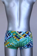 BAck view of vintage 70s Ribana swim trunks in a geometric print with cool tones of blue, green, yellow, and navy, modeled on a silver mannequin.