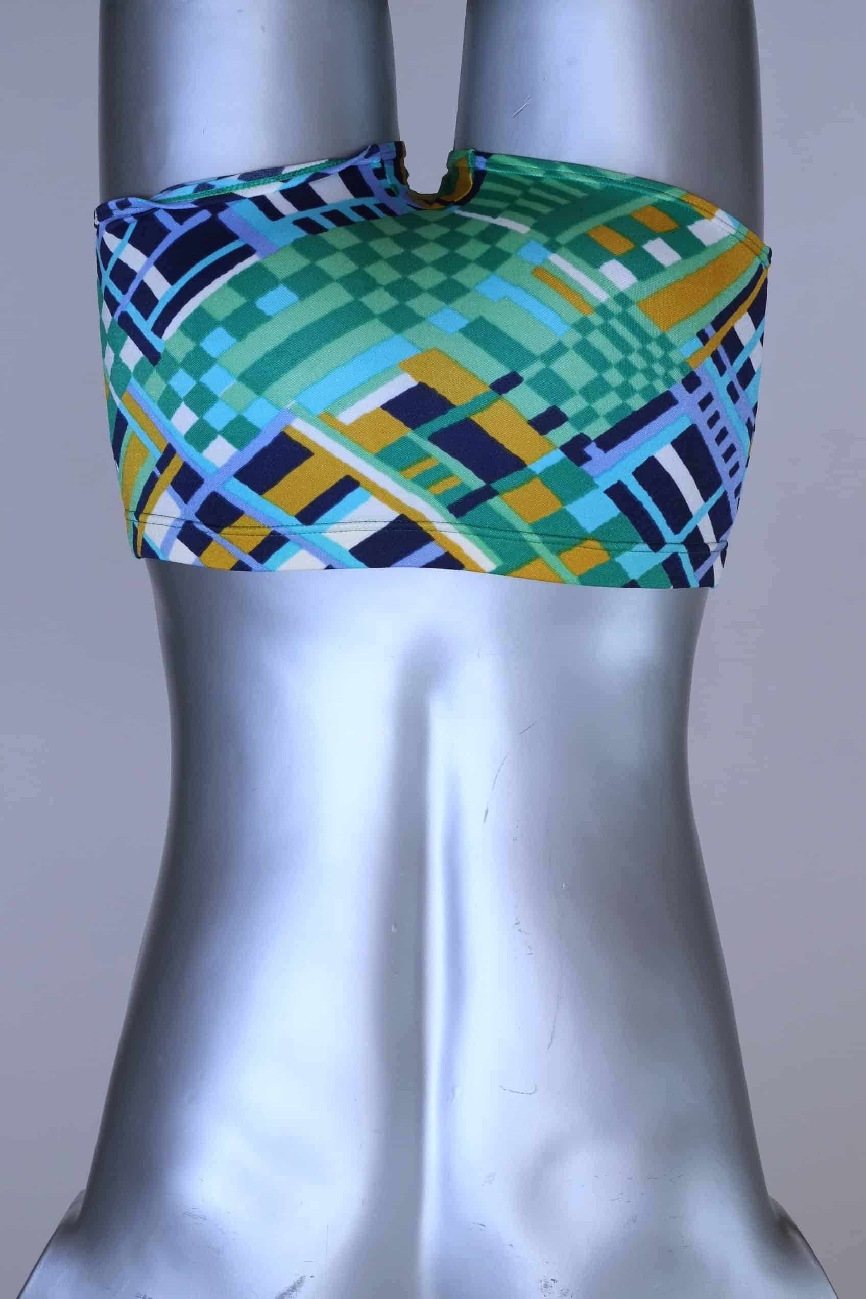 BAck view of vintage 70s Ribana swim trunks in a geometric print with cool tones of blue, green, yellow, and navy, modeled on a silver mannequin.