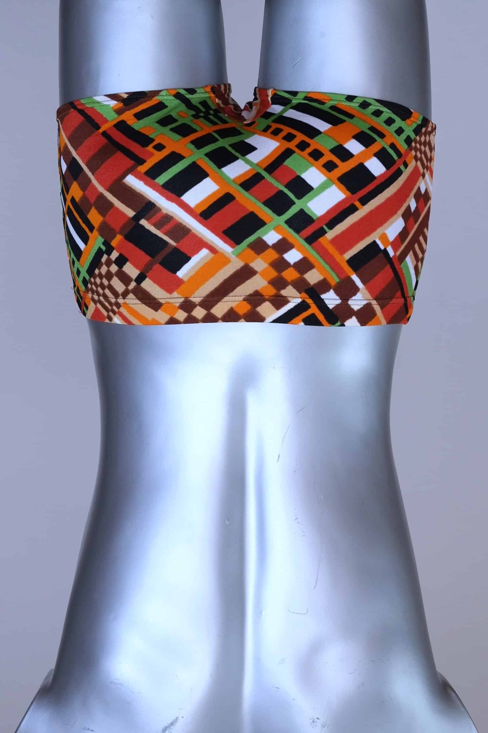 Back view of vintage 70s Ribana swim trunks in a geometric print with warm tones of orange, brown, green, and black, modeled on a silver mannequin.
