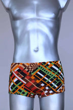 Front view of vintage 70s Ribana swim trunks in a geometric print with warm tones of orange, brown, green, and black, modeled on a silver mannequin.