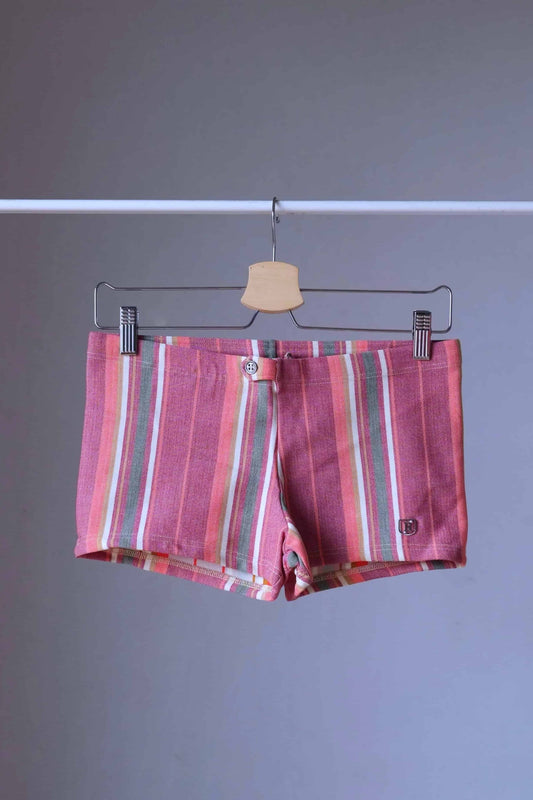 Vintage 70s Ribana Carsten men's swim trunks with vertical stripes in red, green, white, and peach tones, displayed on a hanger against a neutral background.