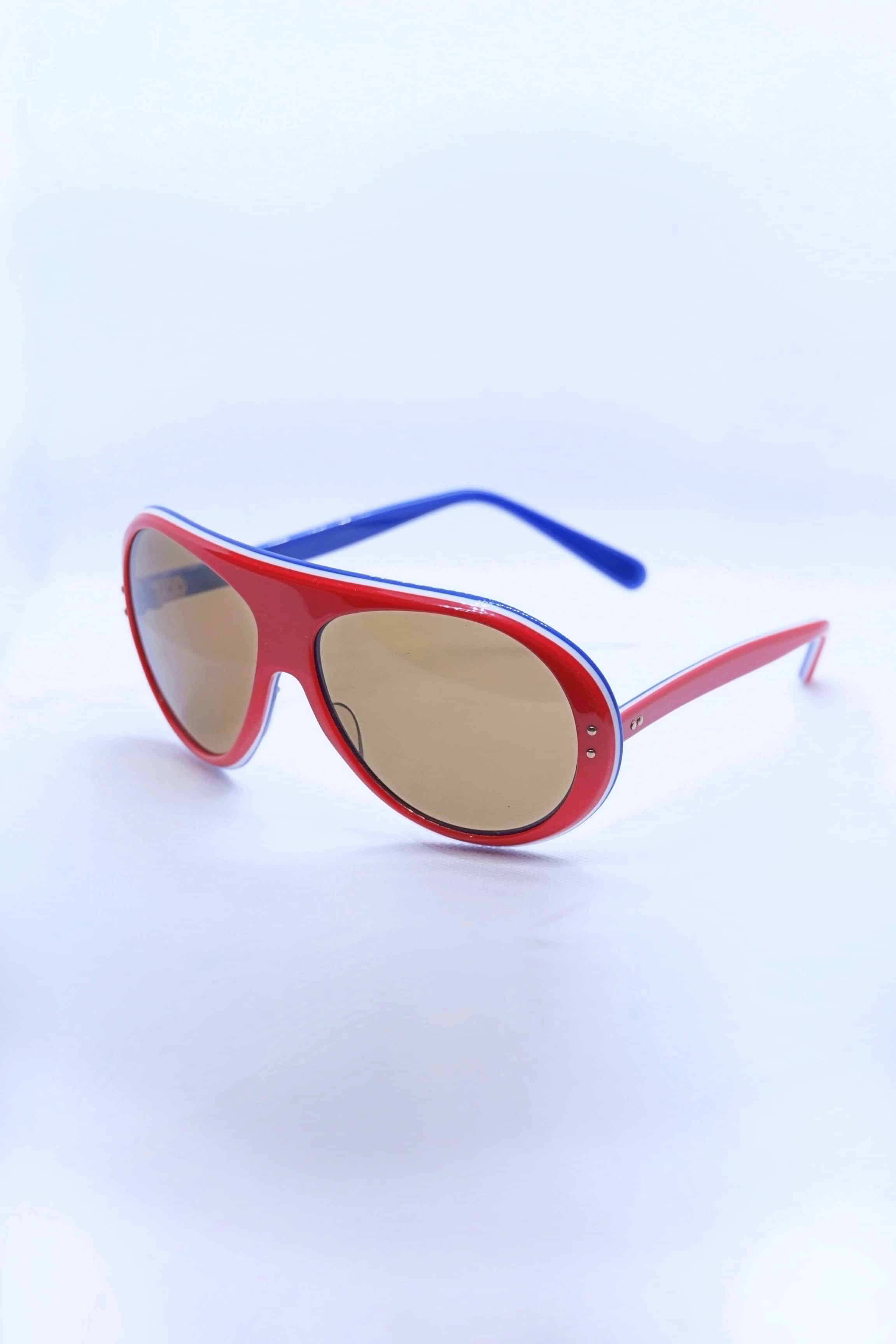 Red and blue 1970s vintage SKILOOK tricolor aviator sunglasses with brown lenses, featuring a thick red acetate frame, white accent striping, and mismatched red and blue temples.
