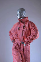 Coral 90s ski suit on a mannequin, showing belt buckle, patterned fabric, and drawstring details.