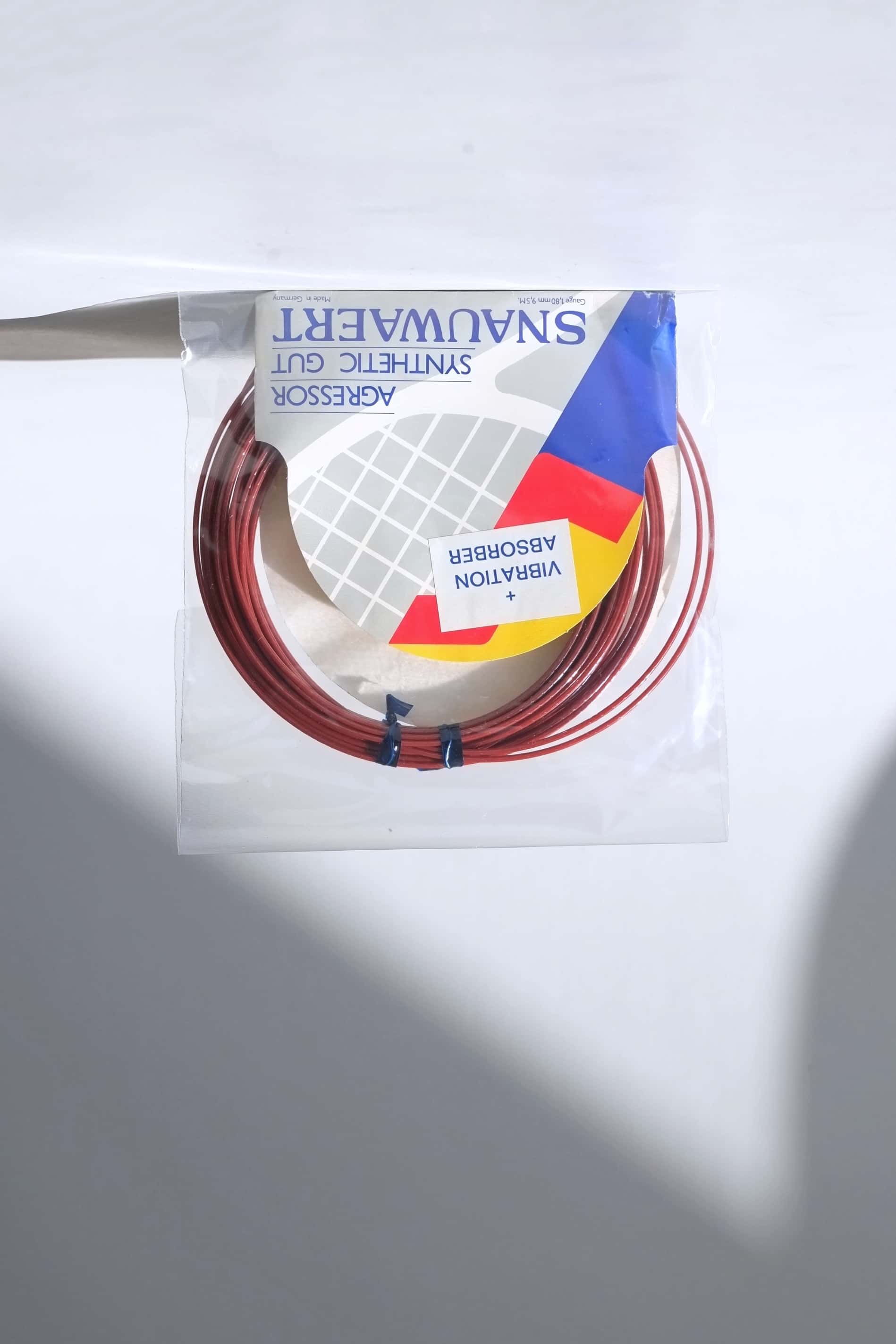 Deadstock vintage Snauwaert Agressor synthetic gut tennis strings in their original gold, blue, and white retail packaging.