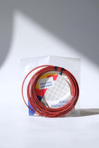 Coiled vintage Snauwaert Agressor synthetic gut tennis strings removed from the packaging to show the texture and color.