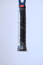Detail shot of the racquet handle variation wrapped in a black synthetic Snauwaert grip with a red "Inspected By 6" sticker at the top.