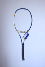 Studio full front shot of an unstrung variation of the racquet featuring a black grip and a blue Snauwaert warranty hang tag attached to the throat.