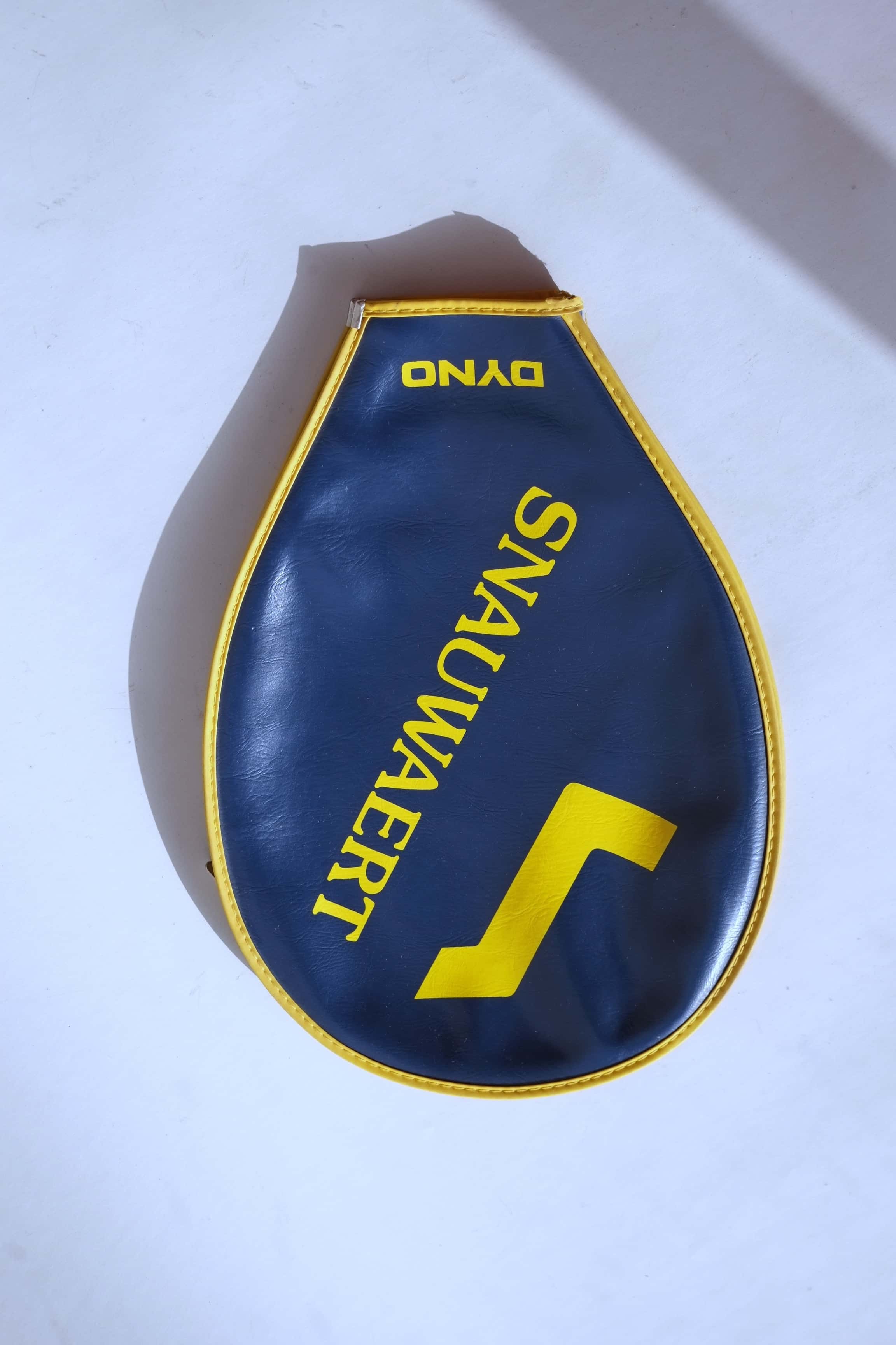 Top-down view of the full navy blue vinyl racquet cover featuring a large yellow Snauwaert logo and name, framed by a yellow stitched trim.