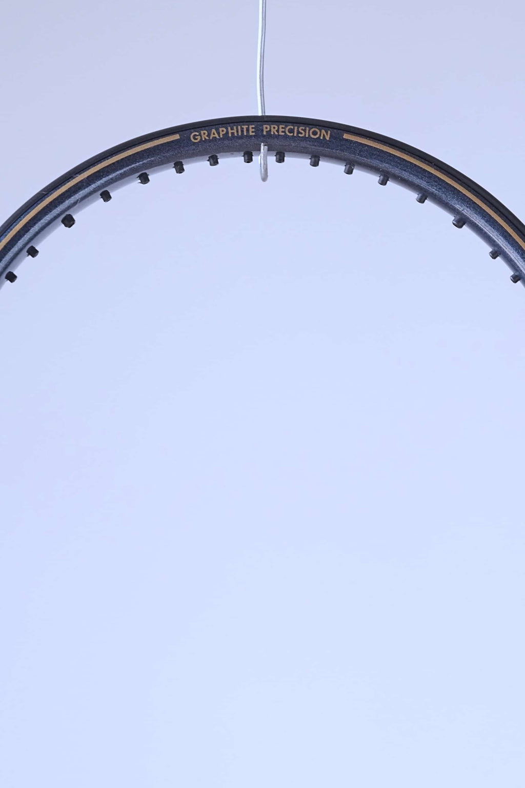 Close-up of the top curve of the racquet frame featuring the "GRAPHITE PRECISION" model name in gold lettering.