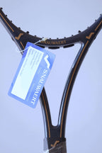 Frontal close-up of the open racquet throat displaying the "SNAUWAERT" name in gold and the brand's stylized "S" logo on the shoulders.