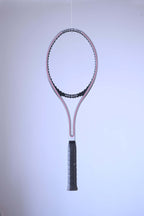 Studio full shot of an unstrung black and white Snauwaert Graphite Pro tennis racquet suspended against a plain white backdrop.