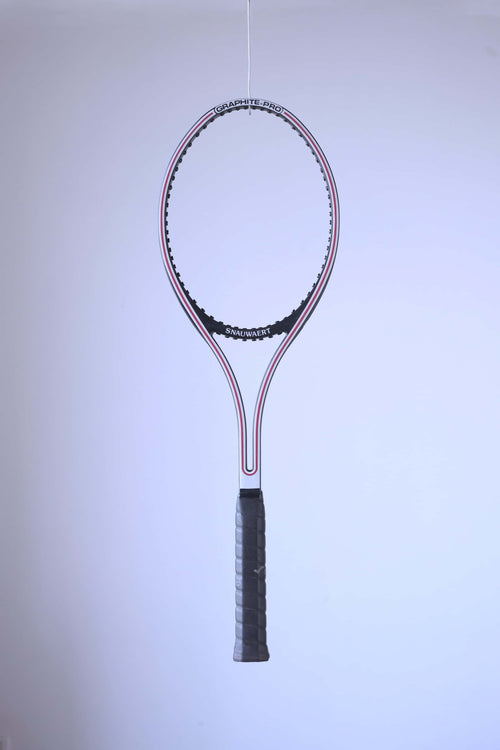Studio full shot of an unstrung black and white Snauwaert Graphite Pro tennis racquet suspended against a plain white backdrop.