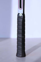 Detail of the racquet handle wrapped in a black textured grip with a round "Quality Control 4" sticker at the top.