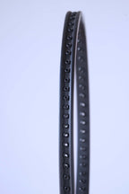 Profile view of the empty black racquet frame showing the precise row of grommet holes for stringing.