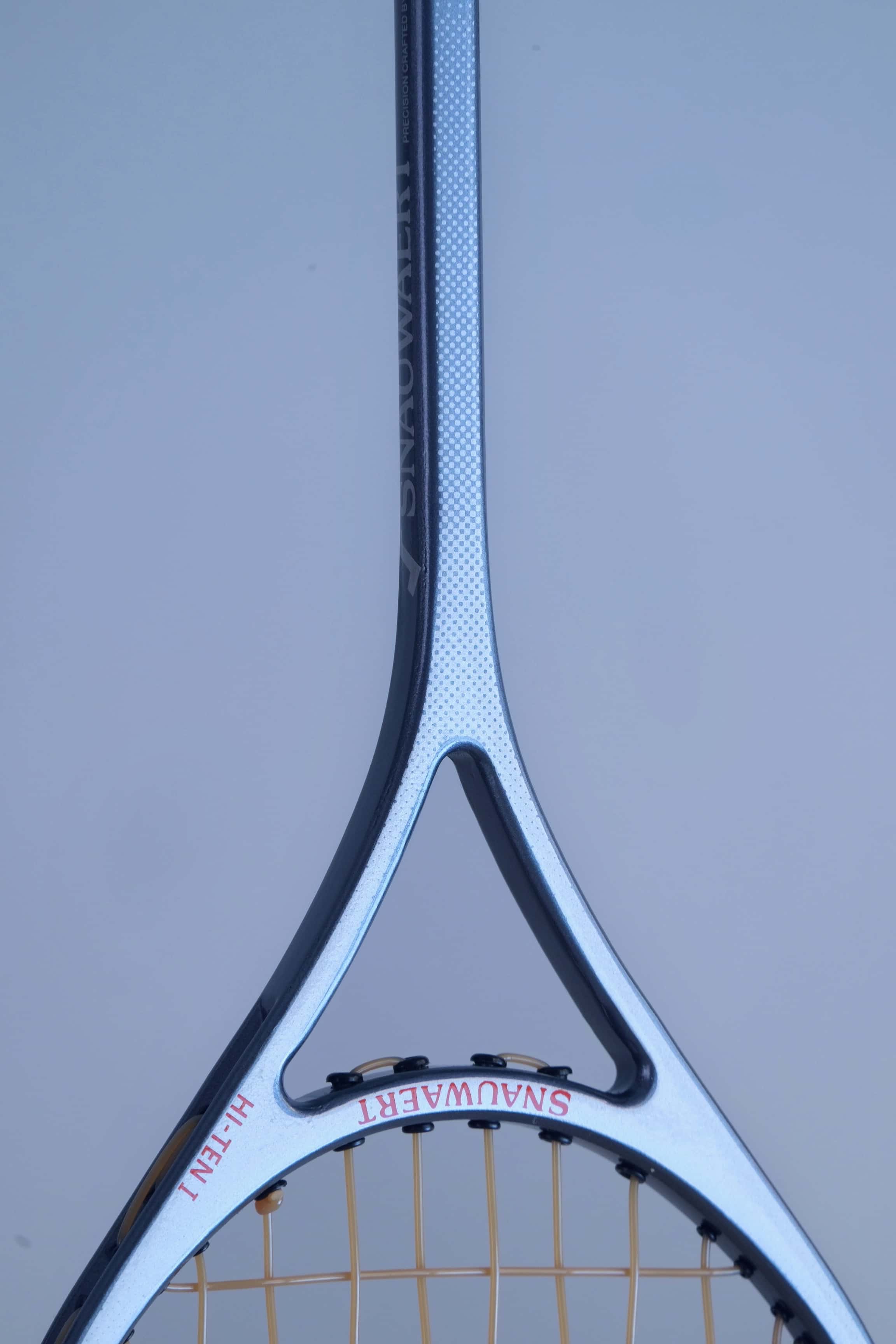 Close-up of the glossy black and silver racket shaft detailing the Snauwaert logo and Hi-Ten I model name.