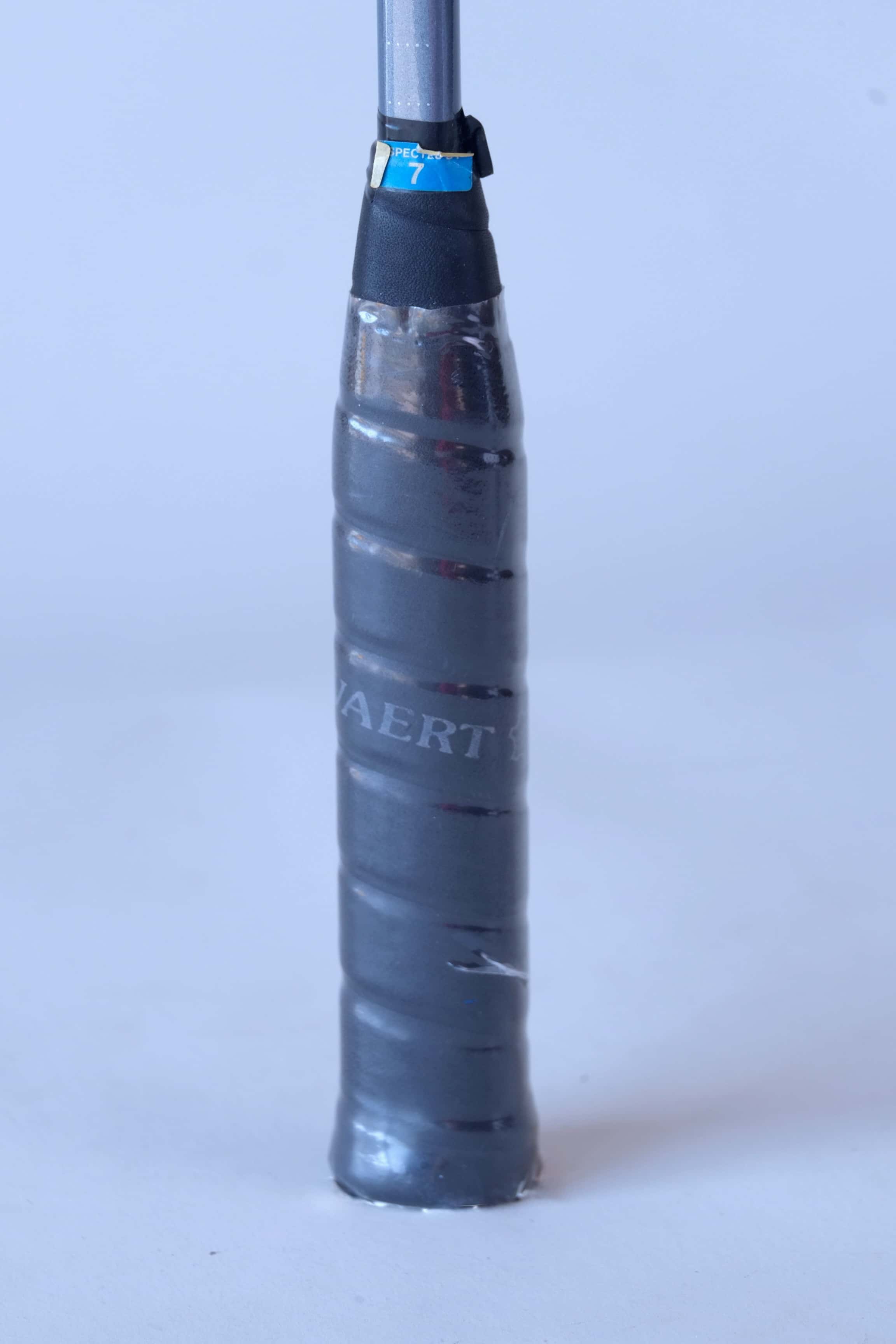Close-up of the original textured black leather wrap grip on a vintage Snauwaert squash racket handle.