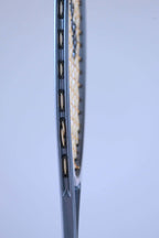 Close-up view of the outer side of the frame showing the plastic string grommets of a vintage squash racket.