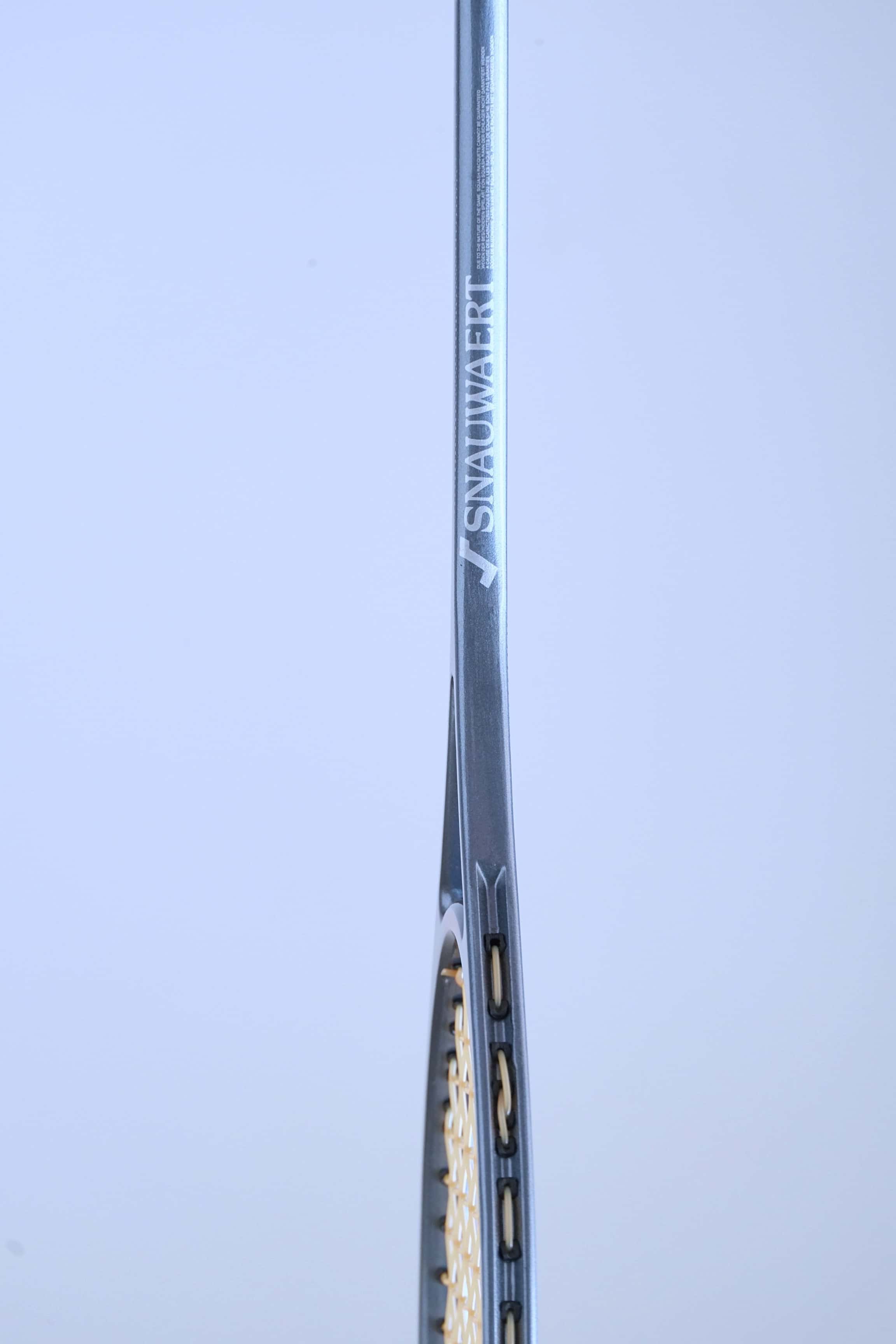 Side profile view of a vintage squash racket shaft showing the text Precision Crafted by Snauwaert & Depla Belgium.