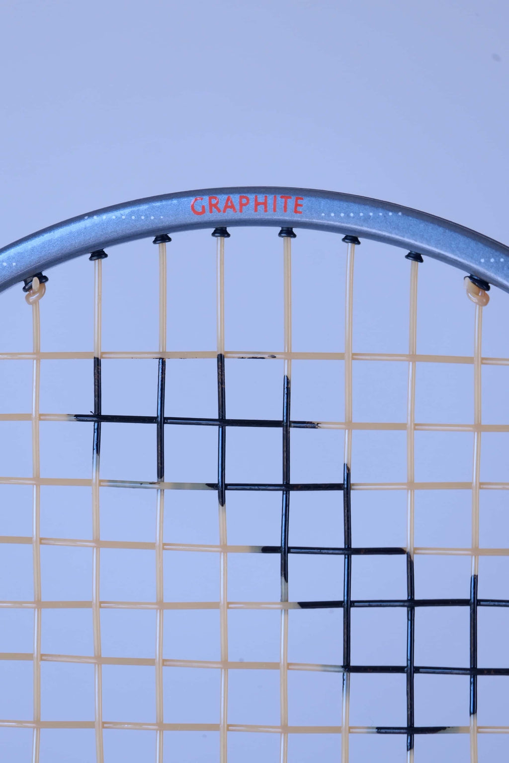 Detailed close-up of the nylon strings grid pattern on a vintage Snauwaert Hi-Ten I squash racket.