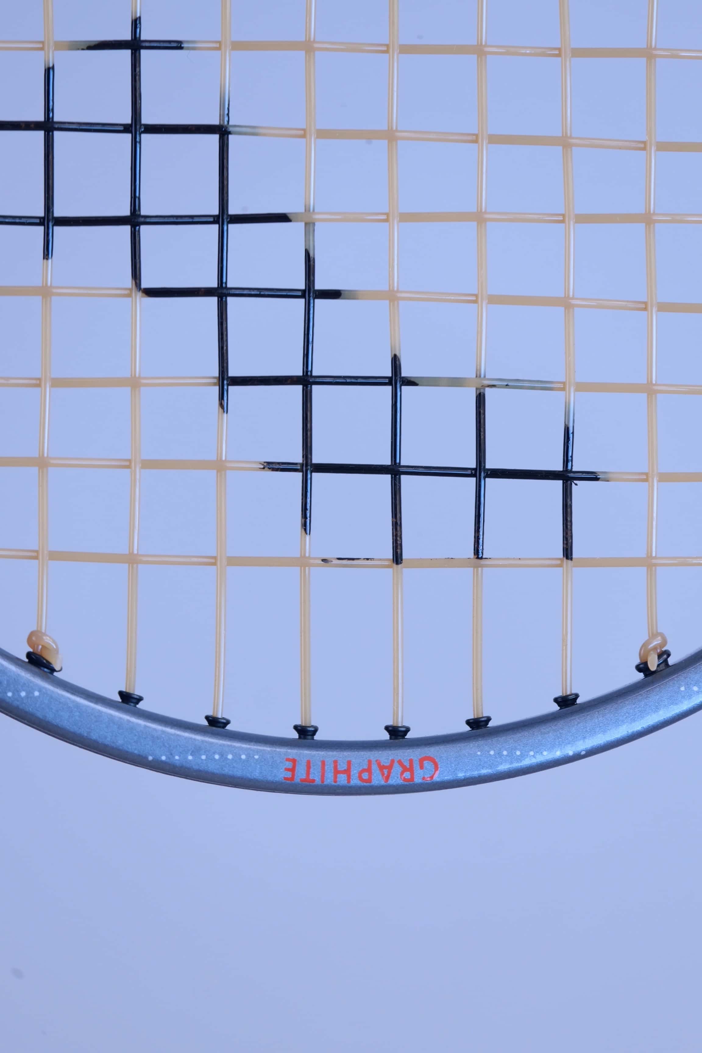 Detailed close-up of the nylon strings grid pattern on a vintage Snauwaert Hi-Ten I squash racket.