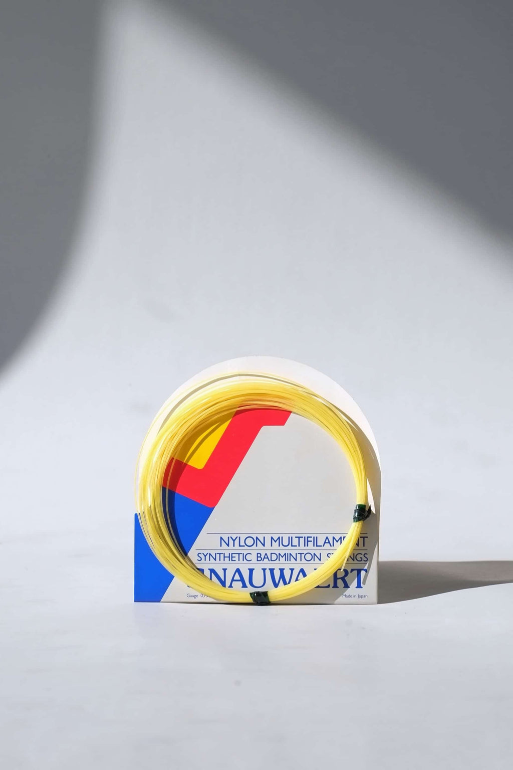 Close-up of a vintage pack of Snauwaert badminton strings, showing the retro logo design and product specifications.