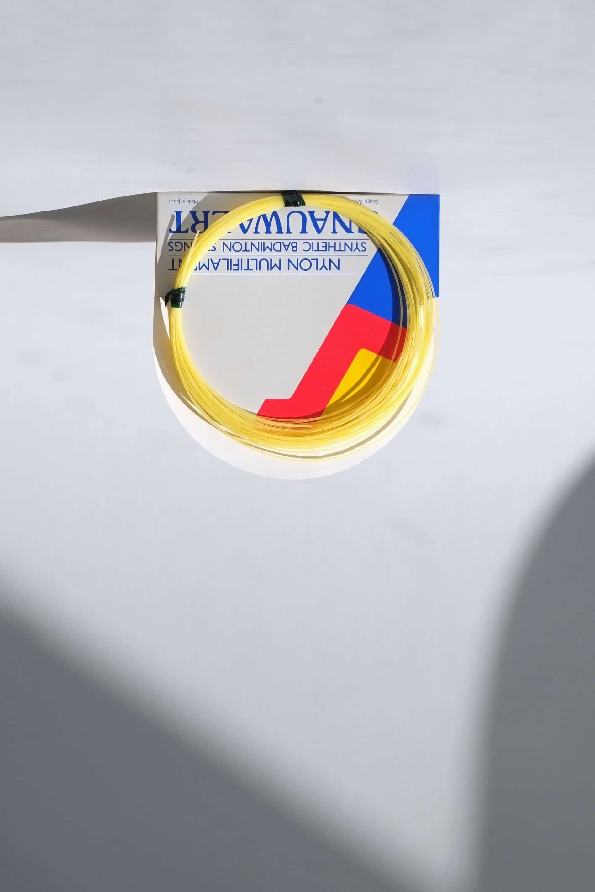 Close-up of a vintage pack of Snauwaert badminton strings, showing the retro logo design and product specifications.
