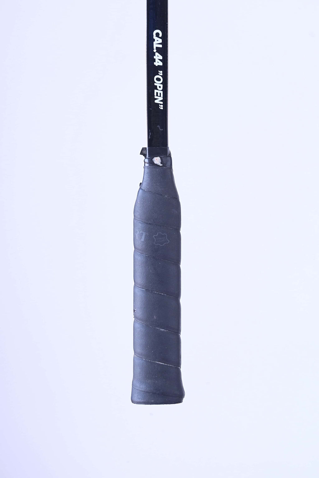 Close-up of the original textured black leather grip handle on a vintage Snauwaert squash racket.