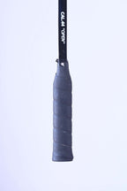 Close-up of the original textured black leather grip handle on a vintage Snauwaert squash racket.