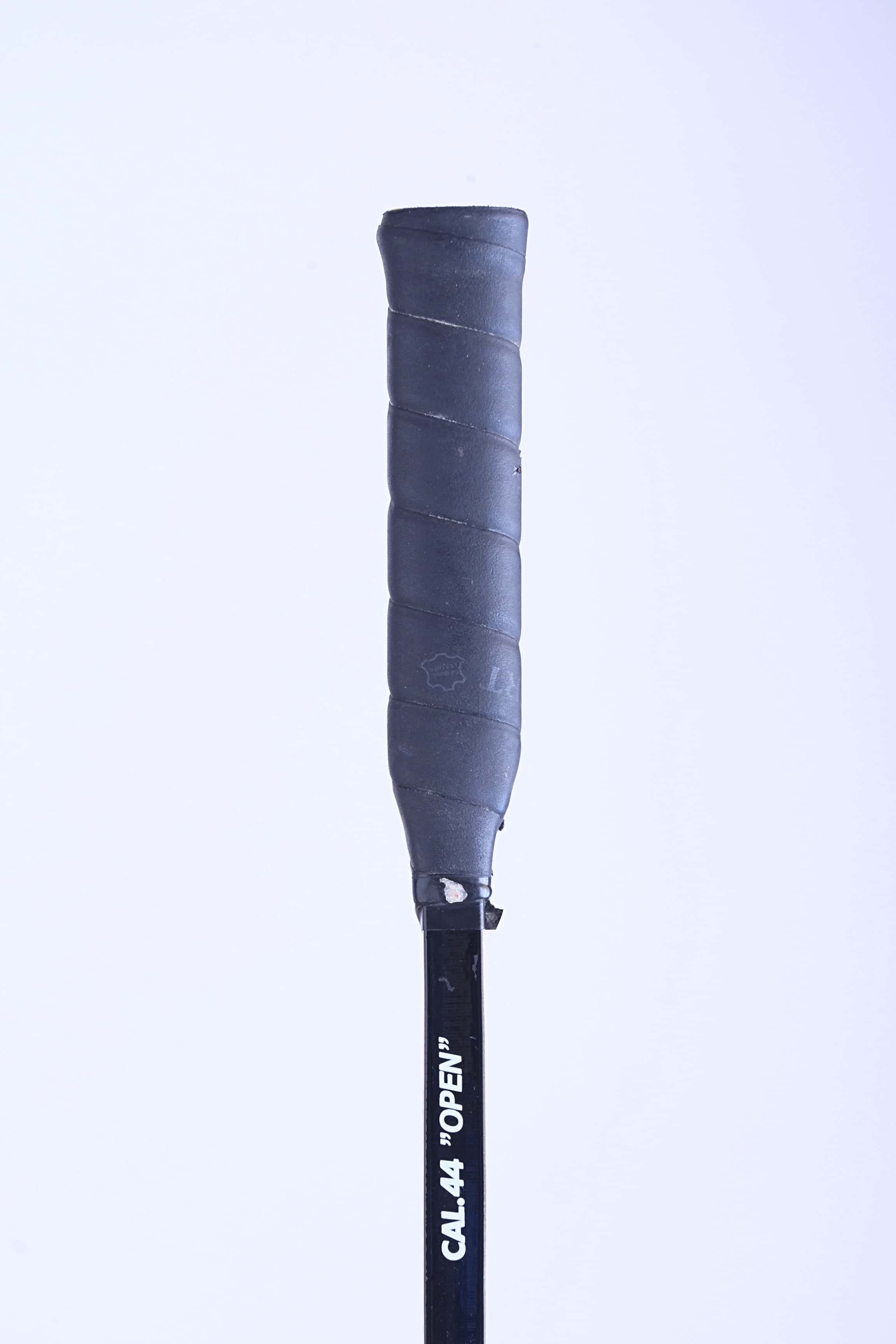 Close-up of the original textured black leather grip handle on a vintage Snauwaert squash racket.