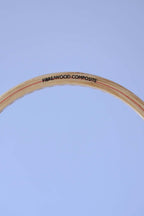 Close-up of the top curve of a vintage wood squash racket frame showing the text Fibre Wood Composite.