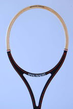 Close-up of the open split-throat design of a vintage Snauwaert squash racket with black and red graphics.