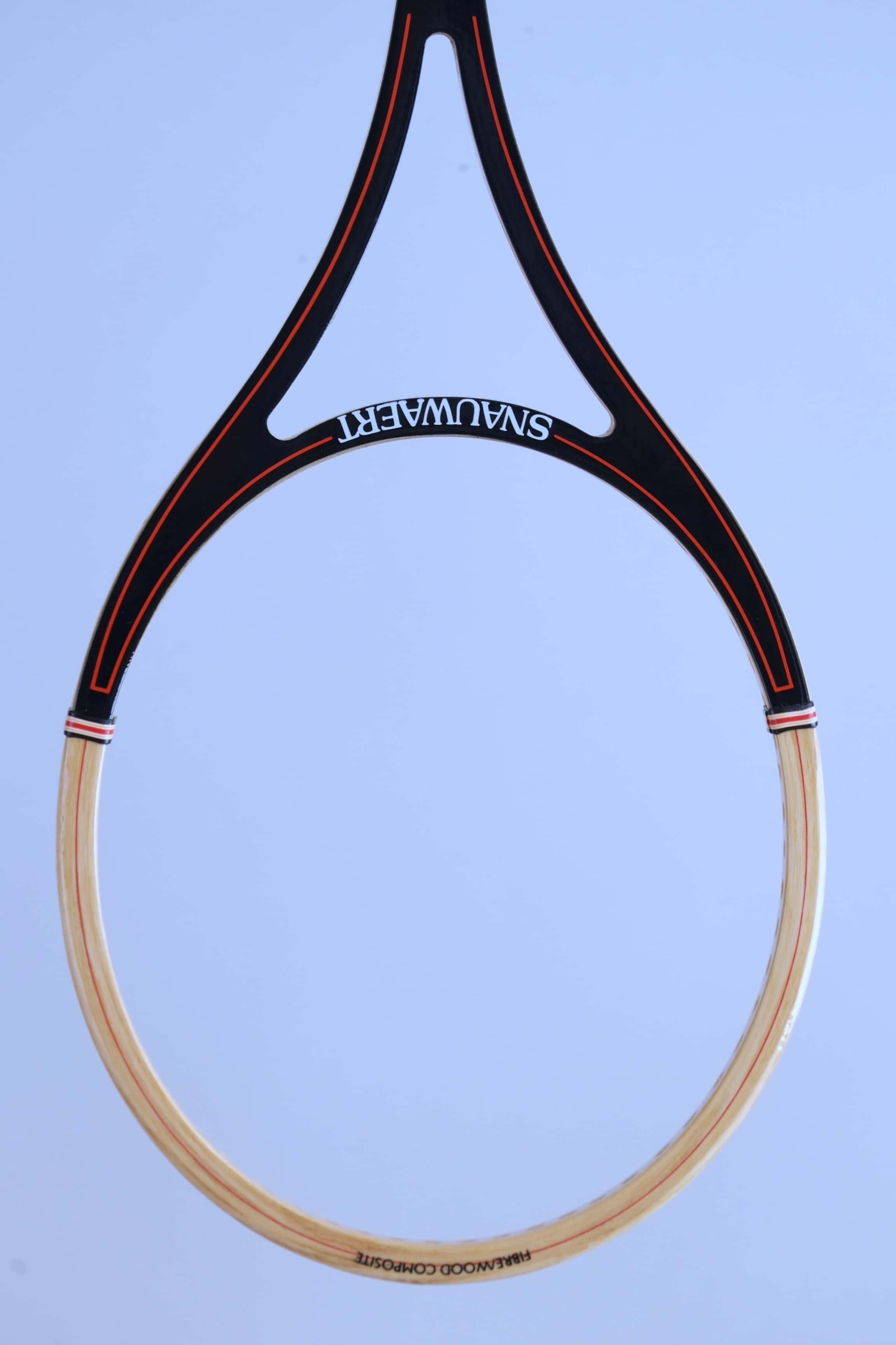 Close-up of the open split-throat design of a vintage Snauwaert squash racket with black and red graphics.