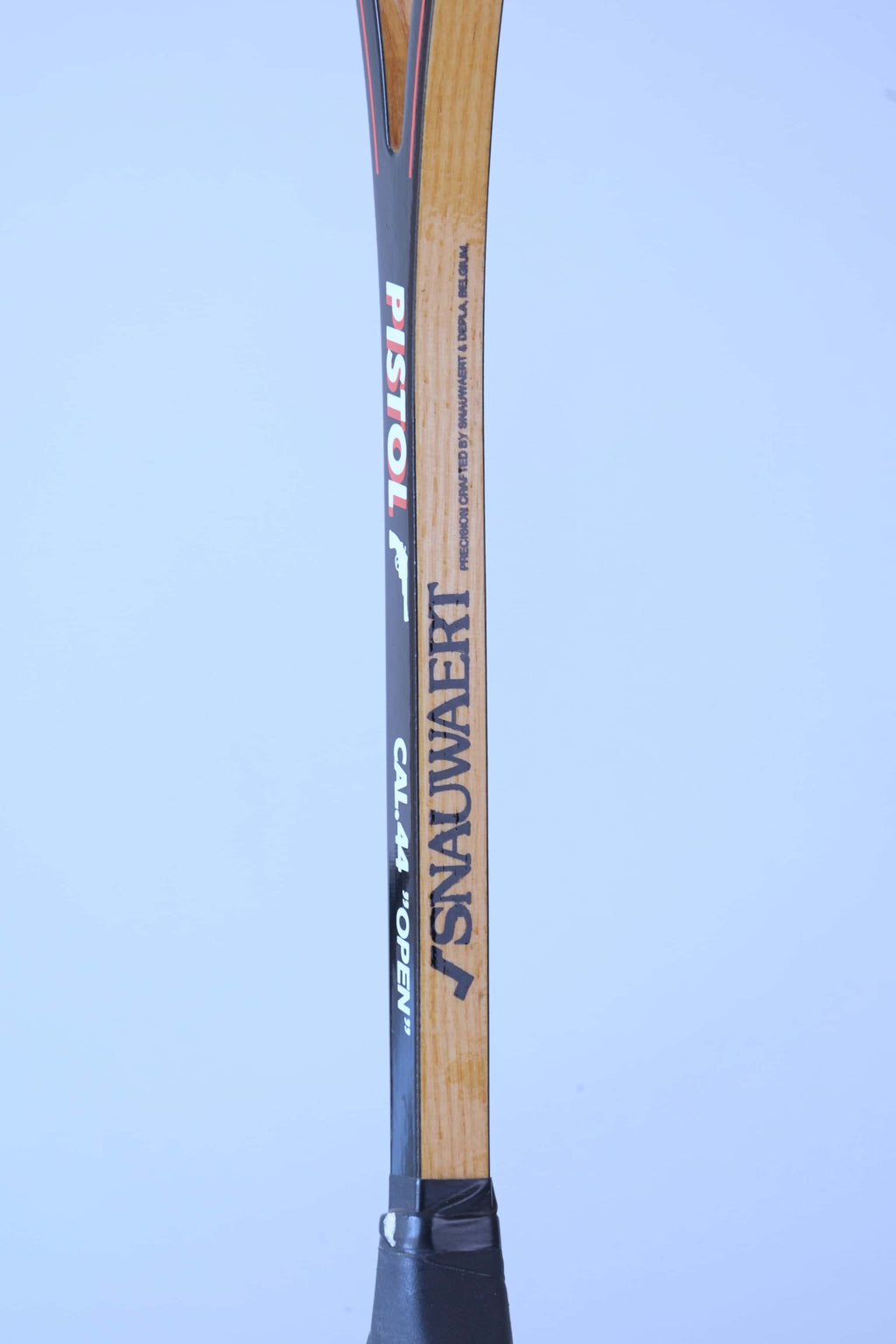 Close-up of a vintage squash racket shaft detailing the Snauwaert logo, Pistol model name, and Cal 44 Open text.