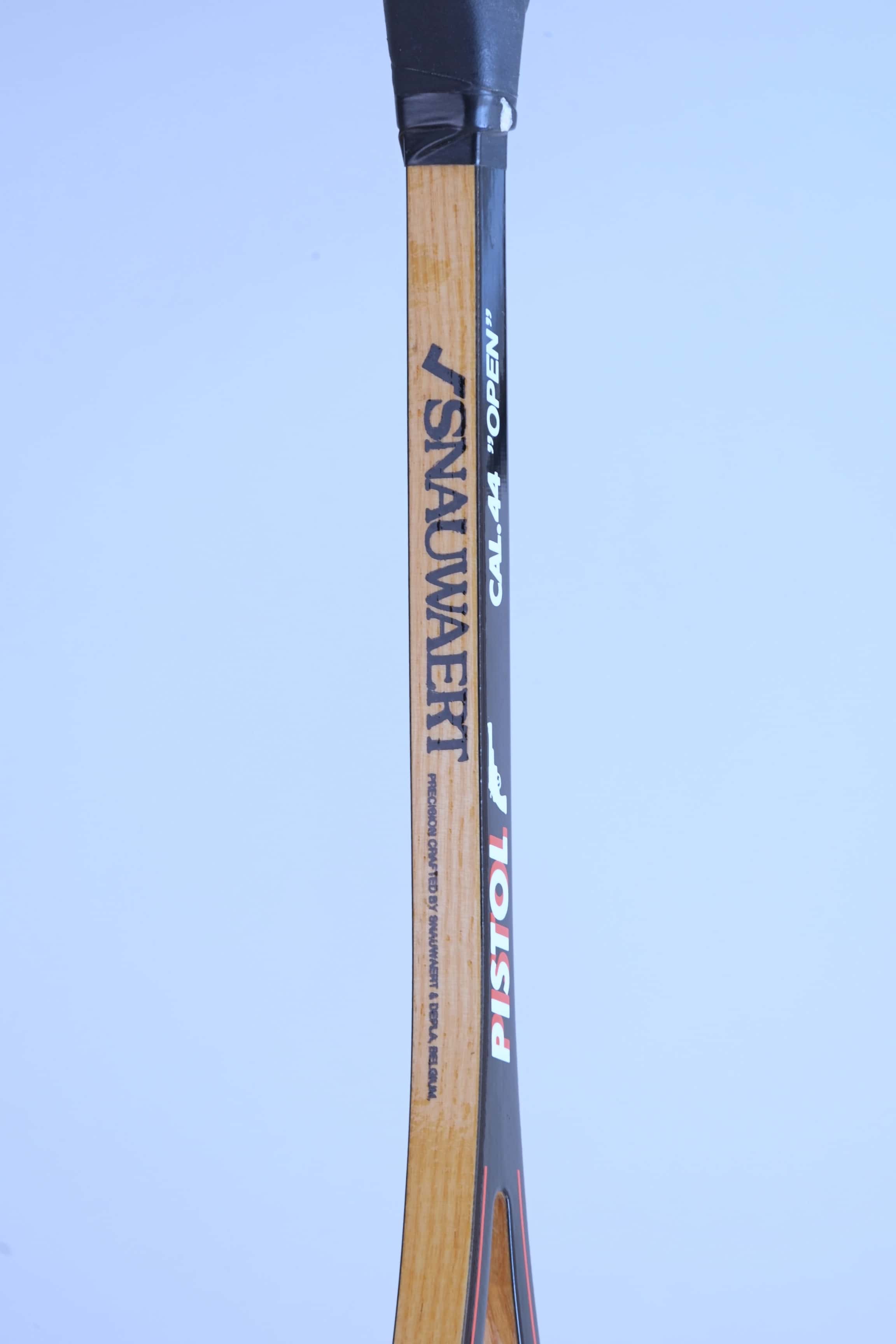 Close-up of a vintage squash racket shaft detailing the Snauwaert logo, Pistol model name, and Cal 44 Open text.