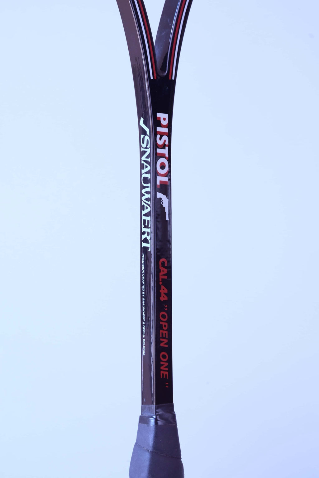 Close-up of a glossy black squash racket shaft showing the Snauwaert and Pistol logos alongside Cal 44 Open One text.