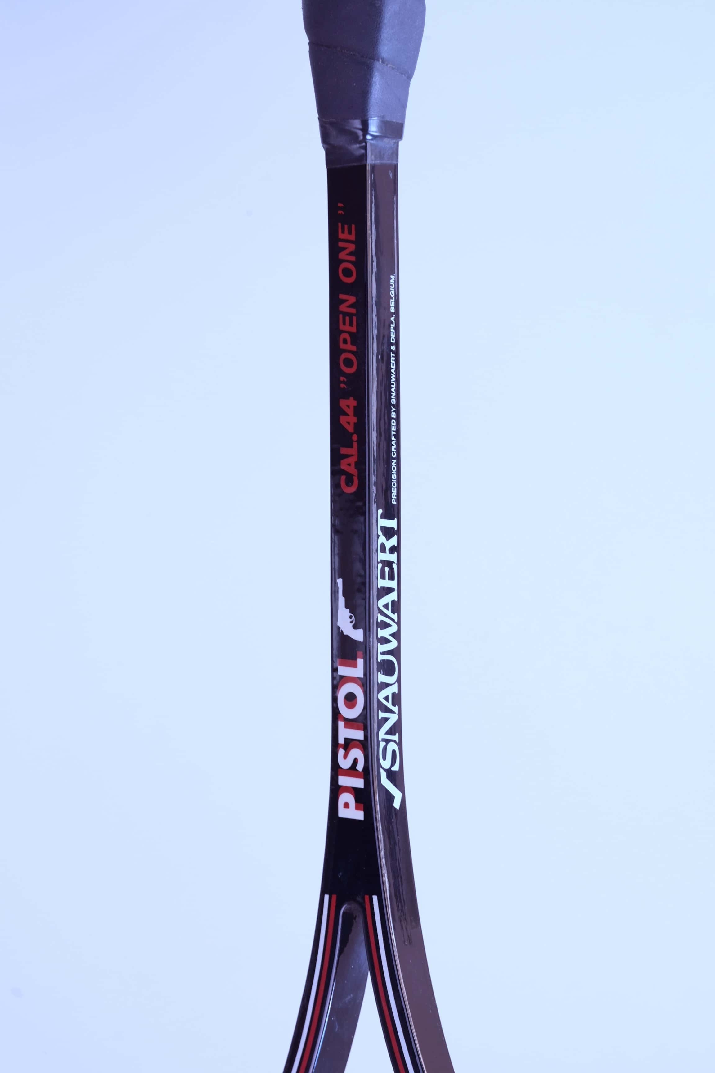 Close-up of a glossy black squash racket shaft showing the Snauwaert and Pistol logos alongside Cal 44 Open One text.